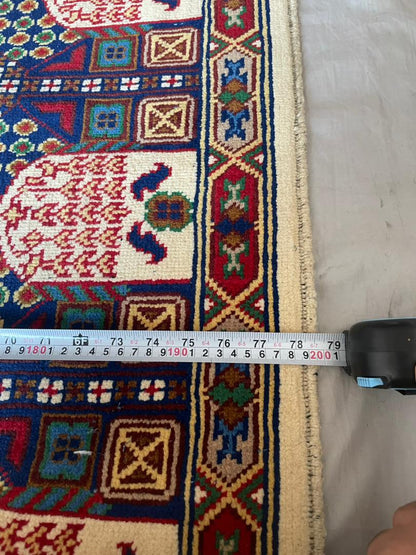 Colorful patterned rug with a measuring tape indicating dimensions on a light gray floor.